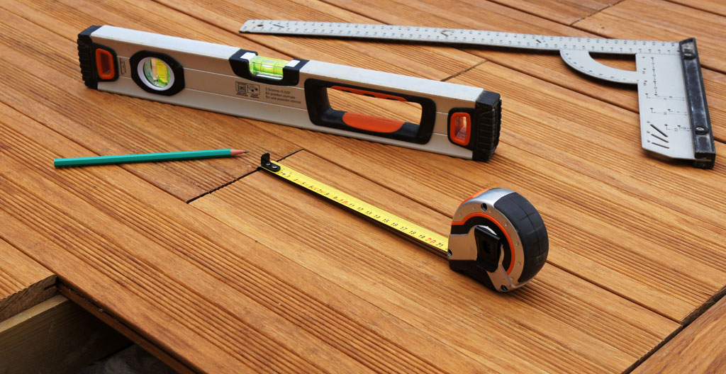 Artisan vérifiant espacement entre lames de terrasse bois